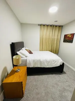 a bedroom with a bed and a table in it at Modern 2-bed 1-bath Suite in Calgary