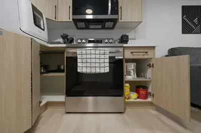 a kitchen with a stainless steel stove and a microwave at Modern Suite by Hospital 2 Near Transit, Wi-Fi, Netflix in Edmonton