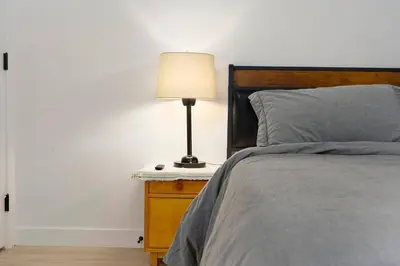 a bedroom with a bed with a lamp on a night stand at Modern Suite by Hospital 2 Near Transit, Wi-Fi, Netflix in Edmonton