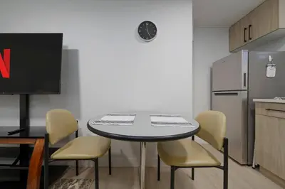 a kitchen with a table and chairs and a refrigerator at Modern Suite by Hospital 2 Near Transit, Wi-Fi, Netflix in Edmonton
