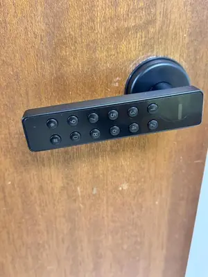 a black door handle on a wooden door at Only 7 km from YYC Sandstone Homestay in Calgary