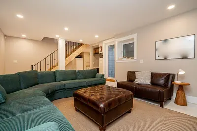 a living room with a green couch and a chair at World Cup Coastal Getaway in White Rock