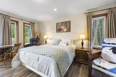 a bedroom with a bed and a chair at Ackerview Guesthouse Bed and Breakfast in Salmon Arm