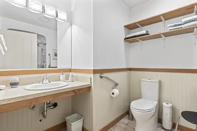 a bathroom with a toilet and a sink and a mirror at Ackerview Guesthouse Bed and Breakfast in Salmon Arm