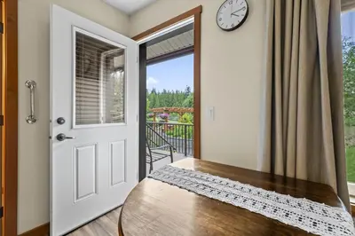 a door leading to a balcony with a clock at Ackerview Guesthouse Bed and Breakfast in Salmon Arm