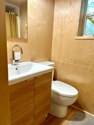 a bathroom with a white toilet and a sink at Riverside Retreat in Cowichan Bay