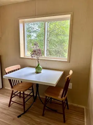 a table with two chairs and a vase with flowers at Riverside Retreat in Cowichan Bay