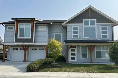 a house with two garage doors in a driveway at Bright & Modern 1-Bedroom Guest Suite in Chilliwack