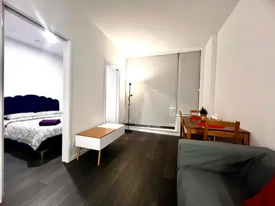 a living room with a bed and a desk in a room at Cozy and convenient 1B1B near Richmond center in Richmond
