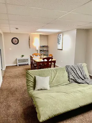 a green couch in a living room with a table at Beautiful Suite Fenced yard Kitchen Laundry in St. Albert