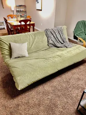 a green couch sitting in a living room at Beautiful Suite Fenced yard Kitchen Laundry in St. Albert