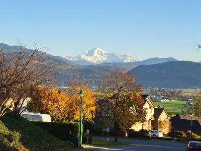 a town with a mountain in the distance with a street at Beautiful Mountain Retreat with a View in Abbotsford