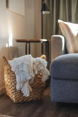 a wicker basket sitting on the floor next to a chair at Modern Lynn Valley Retreat with Mountain and City Views in North Vancouver