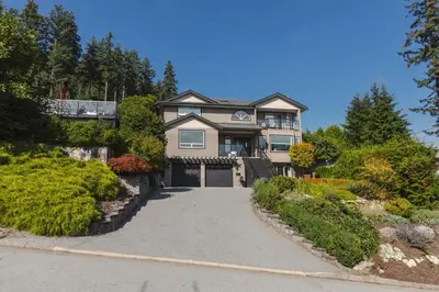a large house with a driveway in front of it at Modern Lynn Valley Retreat with Mountain and City Views in North Vancouver
