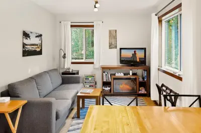 a living room with a couch and a table at Little Bear Cabin at Raven's Moon in Ucluelet