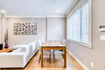 a dining room with a table and a couch at Cozy two beds lower level suite in Vancouver West in Vancouver