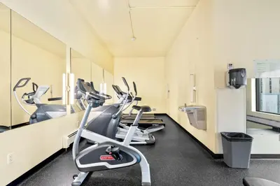 a gym with a row of exercise bikes in it at Central Downtown at Rocky Mountain Court with Gym, Court, Sauna and Secured Parking in Calgary