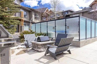 two chairs and a table with a grill on a patio at Bears Den 2BR Getaway with Hot Tub, BBQ Near DT in Dead Man's Flats