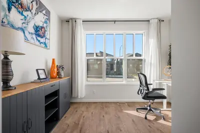 an office with a desk and a chair in front of a window at Brand New Cozy2BR House NW Calgary DT Banff Sleep4 in Calgary