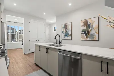 a kitchen with white cabinets and a sink at Brand New Cozy2BR House NW Calgary DT Banff Sleep4 in Calgary