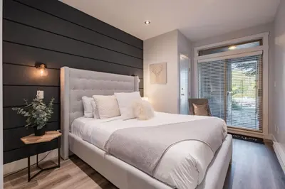 a bedroom with a large white bed and a window at Symphony 8 by Outpost Whistler in Whistler