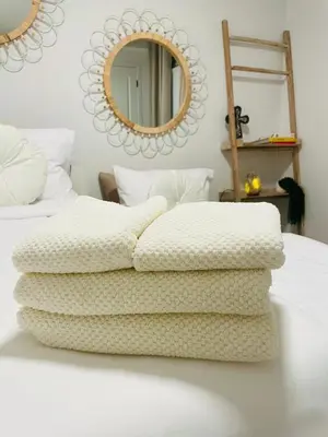 a stack of blankets on a bed with a mirror at The SuiteLife, Calgary in Calgary