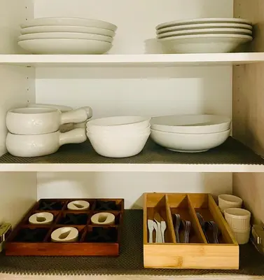 a shelf with plates and bowls and other dishes at The SuiteLife, Calgary in Calgary