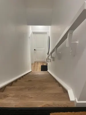 a hallway with stairs leading to a white door at The SuiteLife, Calgary in Calgary
