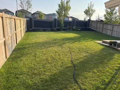 a yard with a fence and a hose at Northern Nook - 2BR Suite in Calgary