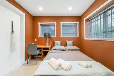 two beds in a room with a desk and windows at Spacious 3BR with Full Kitchen a n dFast Wi-Fi in Vancouver