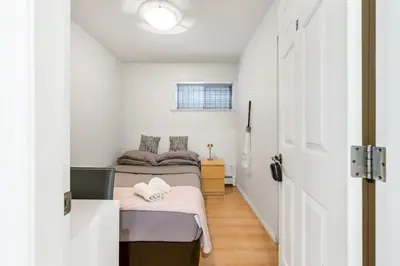 a small bedroom with two beds and a door at Spacious 3BR with Full Kitchen a n dFast Wi-Fi in Vancouver