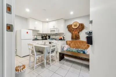 a kitchen with white cabinets and a table and chairs at Spacious 3BR with Full Kitchen a n dFast Wi-Fi in Vancouver