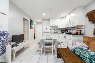 a kitchen and living room with white cabinets and a table at Spacious 3BR with Full Kitchen a n dFast Wi-Fi in Vancouver