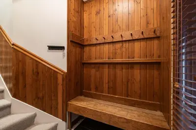 a bathroom with a wooden wall and stairs at Blackcomb Greens 33 by Outpost Whistler in Whistler