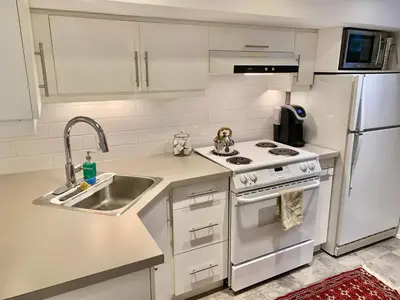 a kitchen with a sink and a refrigerator at Cozy Boho Studio Suite in Calgary