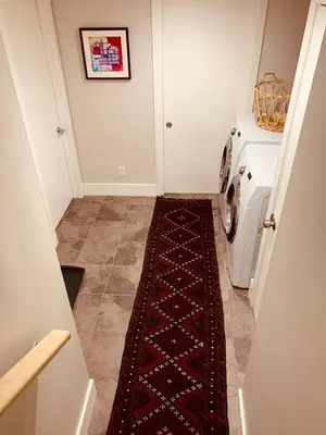a hallway with a washing machine and a rug at Cozy Boho Studio Suite in Calgary
