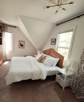 a bedroom with a bed with white sheets and a window at Charming Inner City Home in Calgary