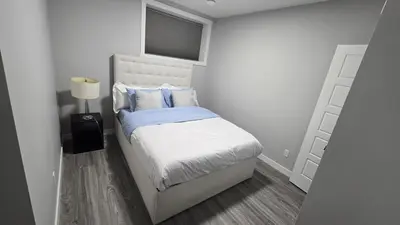 a small bedroom with a bed and a window at Royaldee Cozy Home in Calgary