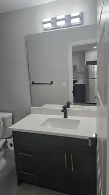 a bathroom with a sink and a mirror at Royaldee Cozy Home in Calgary