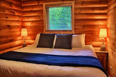 a bedroom with a bed in a log cabin at Wild Renfrew Seaside Cottages in Port Renfrew