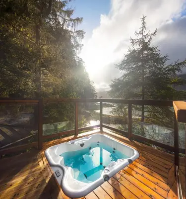 a jacuzzi tub on a wooden deck at Wild Renfrew Seaside Cottages in Port Renfrew