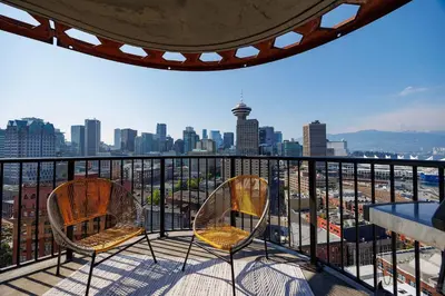 two chairs on a balcony with a view of a city at Spacious 2BD in Vancouver Patio with Ocean View in Vancouver