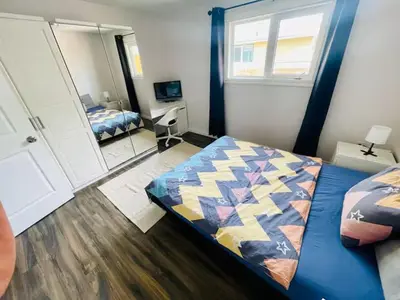 a bedroom with a bed and a mirror at Private Rooms in a Wonderful House in Hay River