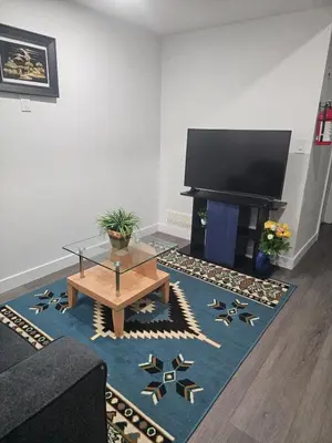 a living room with a television and a table at Affordable Comfort in Creekstone SW in Calgary
