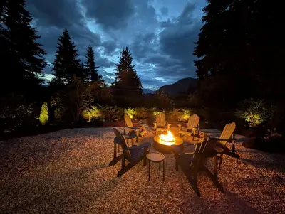 a table and chairs in a yard at night at Newly Renovated Shuswap Lake Cabin Multi-Family Retreat Sleeps 12 in Blind Bay