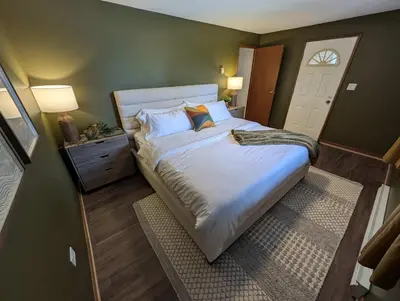 a bedroom with a large bed and a door at Newly Renovated Shuswap Lake Cabin Multi-Family Retreat Sleeps 12 in Blind Bay
