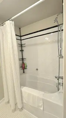 a white bath tub with a shower curtain in a bathroom at Bright 2BR Close to Seabus, and Lower Lonsdale in North Vancouver