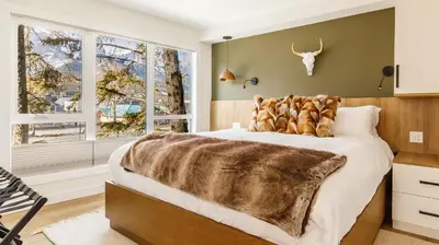 a bedroom with a large bed with a fur blanket at Ravens Nest - Private Hot Tub in Canmore