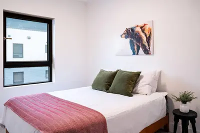 a bedroom with a bed with white sheets and a window at Revelstoke Mountain Penthouse in Revelstoke