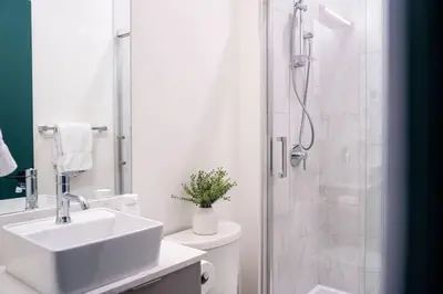 a white bathroom with a sink and a shower at Revelstoke Mountain Penthouse in Revelstoke